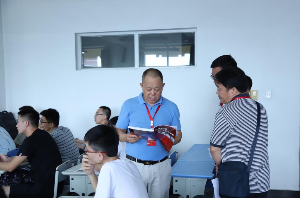 党委书记肖立军在教室查看学生教材